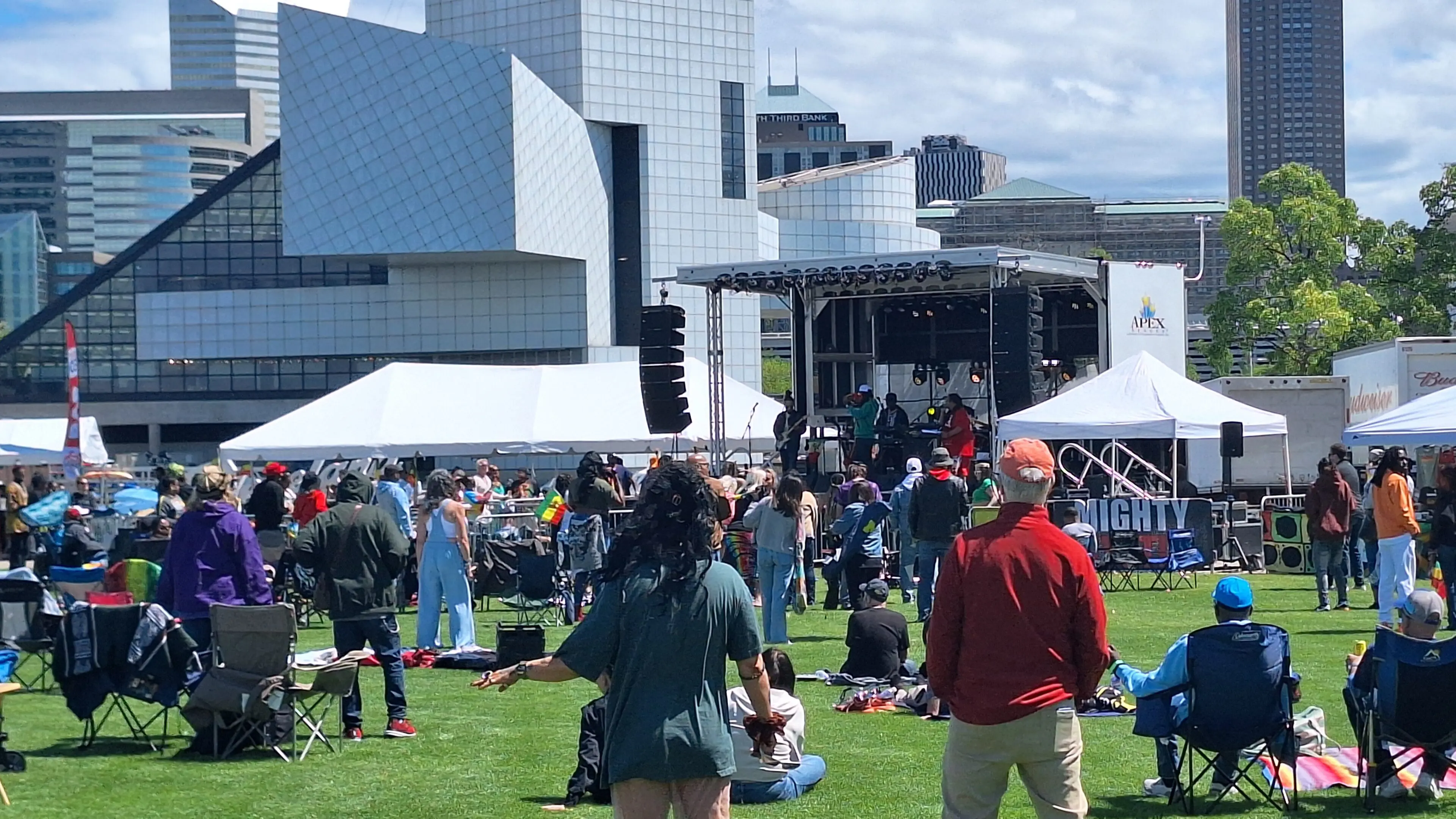 People enjoying an outdoor concert on a sunny day.