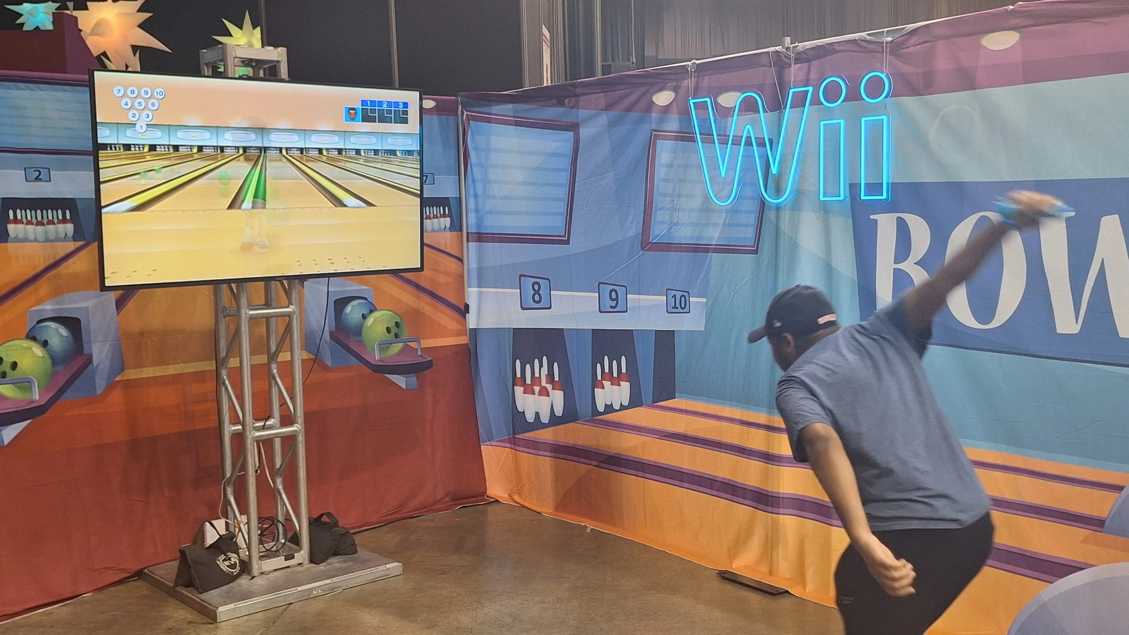 Person playing Wii bowling game with motion controller.
